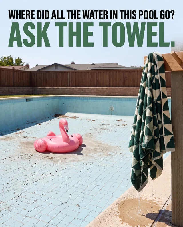 Towel ad with a drained backyard pool and a wet towel hanging poolside
